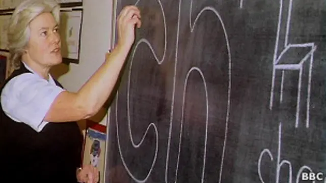 Учительница пишет на классной доске