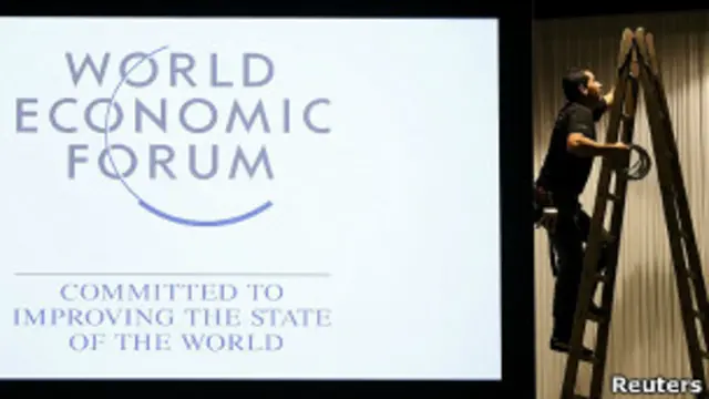 Рабочий готовит стенд на форуме в Давосе
