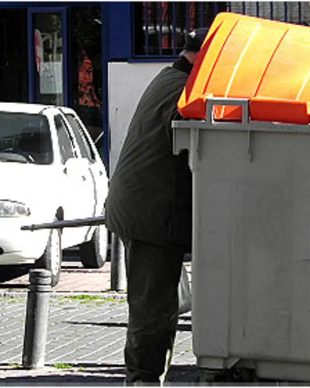 Hombre buscando en un basurero