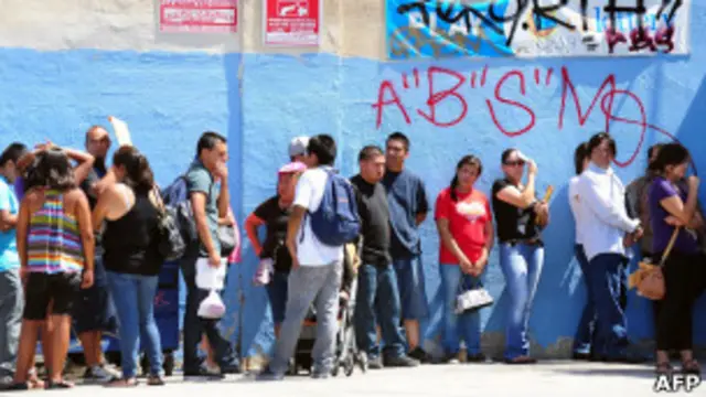 Inmigrantes en fila para entregar solicitudes