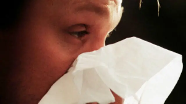 Hombre sonándose la nariz