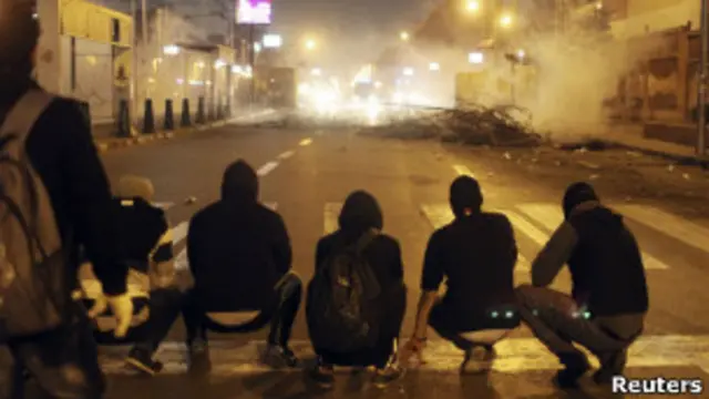 Jóvenes esperan que se despeje el gas lanzado por la policía ante el Palacio Presidencial en Egipto