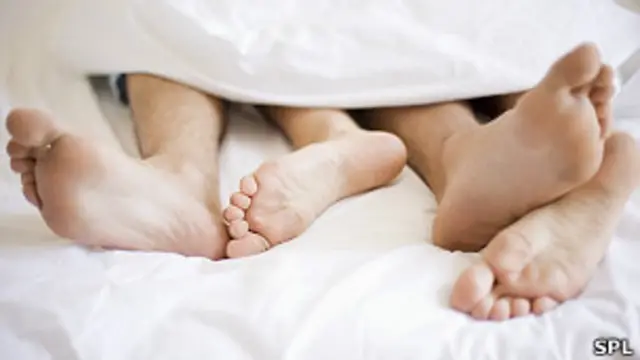 Pies de joven pareja en la cama