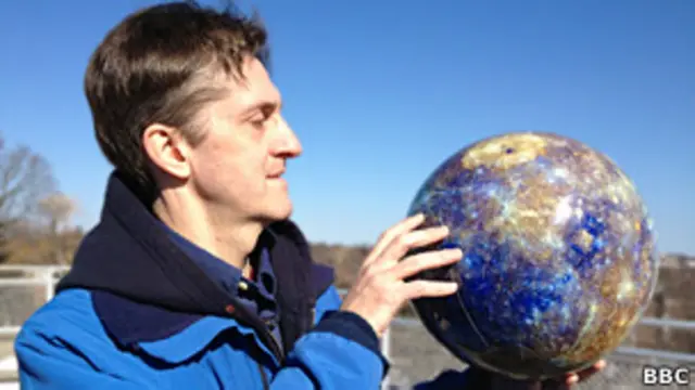 Американский ученый Дэвид Блюитт демонстрирует глобус Меркурия
