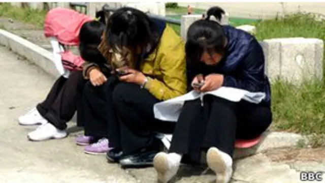 Северокорейцы с мобильными телефонами