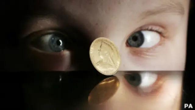 Niño mirando moneda girar