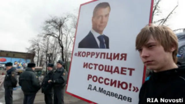 Молодой человек с плакатом на митинге против коррупции на Пушкинской площади в Москве