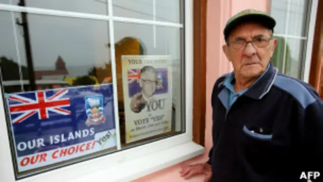 Eleitor passa ao lado de propaganda durante pleito nas Malvinas (foto: AFP)