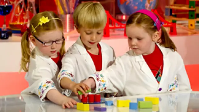 Две девочки и мальчик играют в кубики