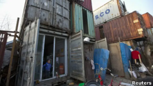 Niño frente a un container usado como vivienda en China
