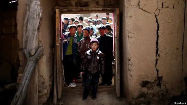 Niños frente a una vivienda precaria en China