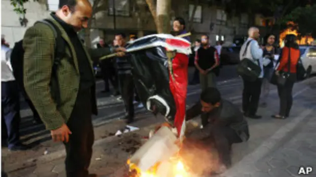 احرق المتظاهرون العلم الليبي أمام السفارة. 