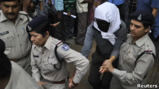 Turista suíça, coberta, é acompanhada por policiais após prestar depoimento
