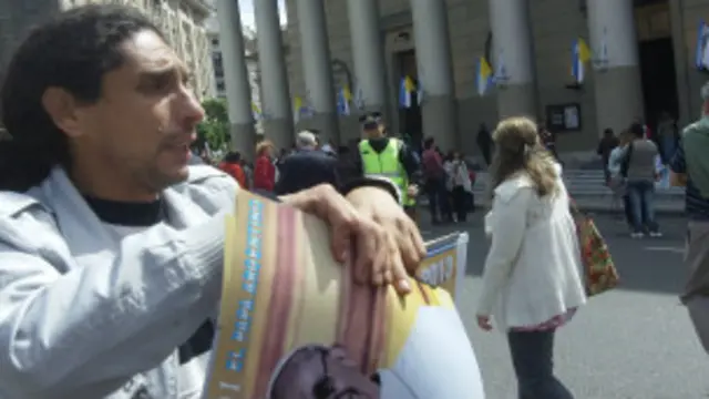 Vendedor de suvenires com pôster do papa em frente à catedral de Buenos Aires (foto: Marcia Carmo / BBC Brasil)