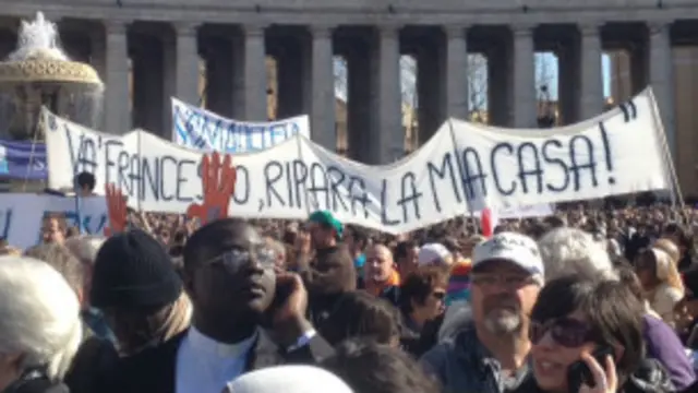 Cartaz exibido por fiéis na praça São Pedro (BBC - Mauricio Moraes)