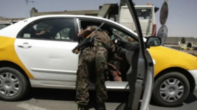 جندي يمني يفتش سيارة في صنعاء