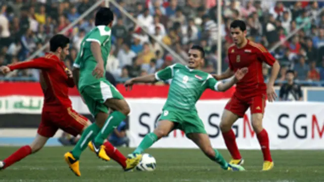 اللاعب العراقي أحمد ياسين يستحوذ على الكرة من بين أرجل اللاعب السوري سنحاريب ملكي