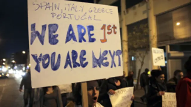 متظاهرة في نيقوسيا ترفع لافتة تقول "نحن السابقون وانتم اللاحقون" في اشارة الى اليونان واسبانيا والبرتغال