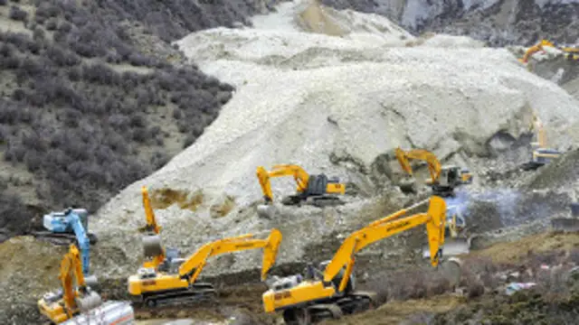 Xe xúc dọn dẹp đất đá ở hiện trường