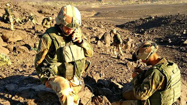 يحمل الجنود معدات ثقيلة