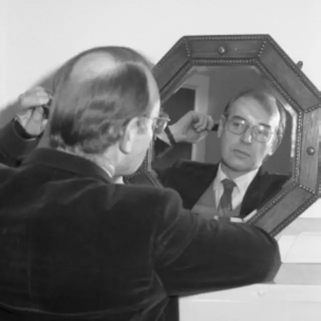 Hombre calvo frente al espejo