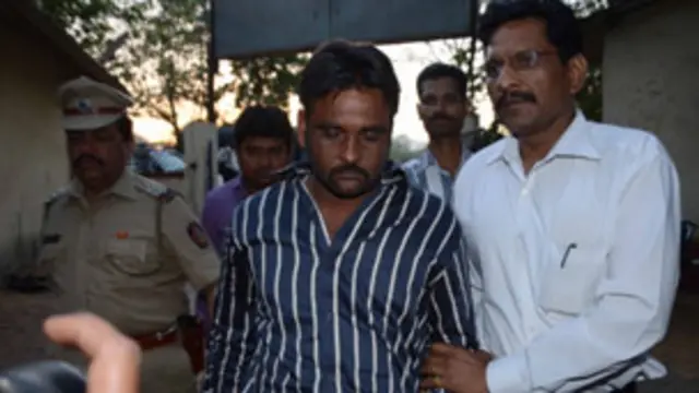 پولیس اہلکار عمارت تعمیر کرنے والوں میں سے ایک جمیل قریشی کو گرفتار کر کے لیجا رہے ہیں۔