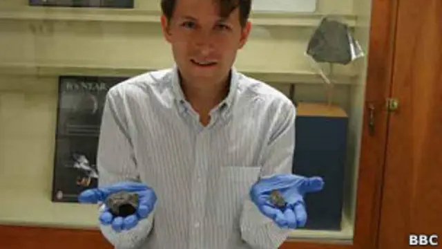 Repórter da BBC segura um fragmento da Luapré aposta esporte betuma das mãos, e umpré aposta esporte betMartepré aposta esporte betoutra (BBC)