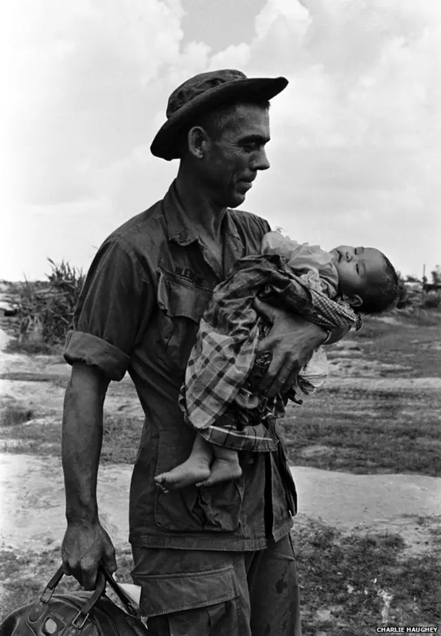 Trung sỹ Edgar D Bledsoe, quê từ Olive Branch, Illinois, ôm em bé Việt Nam bị thương nặng. Em bé sau được đưa vào căn cứ dã chiến của Mỹ để cấp cứu.