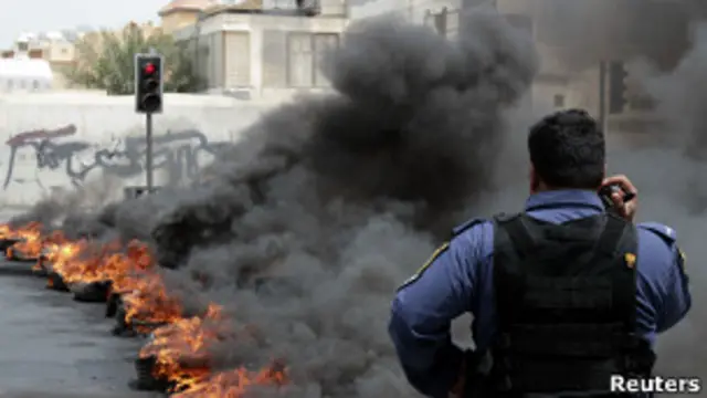 Бахрейнский полицейский и горящие шины