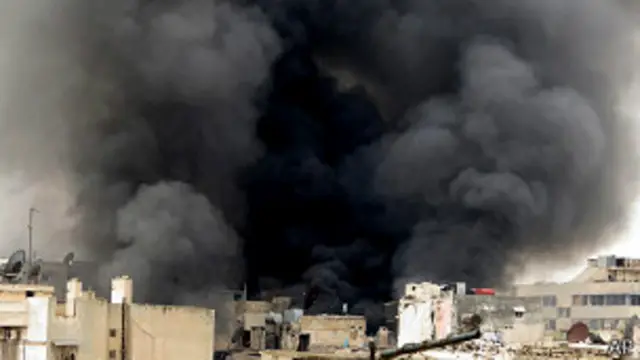 Дым над зданием в Алеппо после обстрела сирийскими правительственными войсками