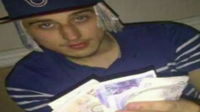 membro da gangue com dinheiro (foto: BBC)