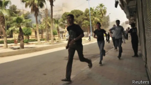 Jovens procuram abrigo durante ataque a Raqqa, no leste da Síria (foto: Reuters)