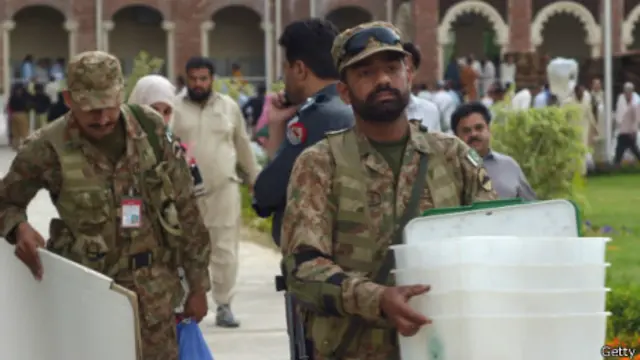 دو سرباز پاکستانی در حال جابجایی وسایل حوزه رای گیری