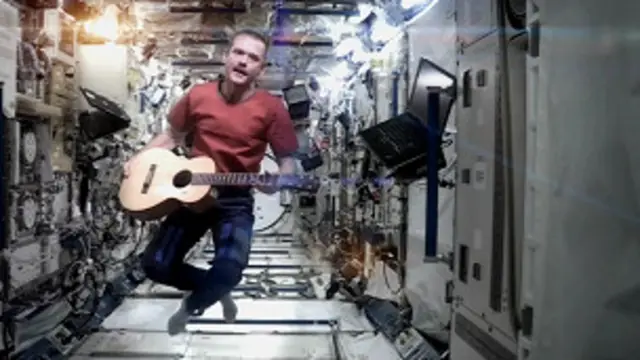 Chris Hadfield segurando um violão e flutuando (crédito: Chris Hadfield, Nasa/CSA)