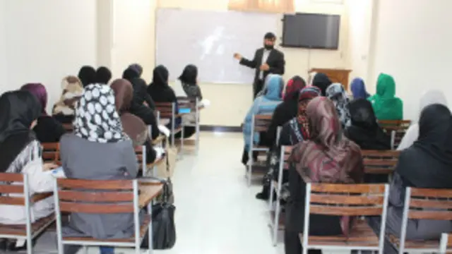 محصلینې یې ټولې نجونې دي، چې بېلابېل رنګه حجابونه یې کړي او پر څوکیو ناستې دي.