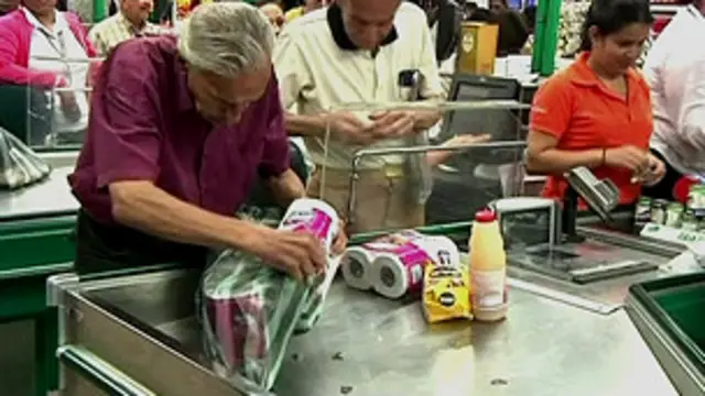 Homem colocando pacotes de papel higiênico em sacola