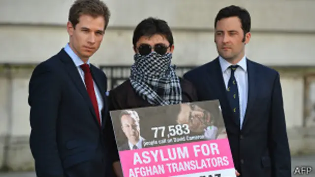 Афганский переводчик с плакатом, требующим права на переселение в Британию, и два бывших британских военнослужащих (3 мая 2013 года)