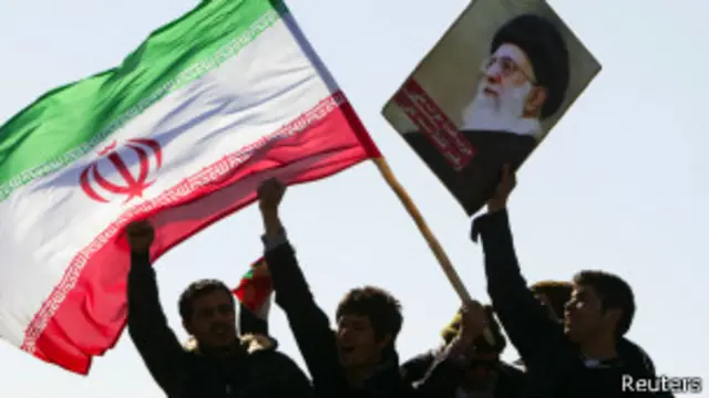 Iranianos com bandeira e foto de Ali Khamenei (Reuters)