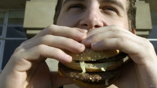 Человек ест гамбургер