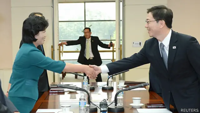 韩国统一部统一政策室室长千海成(右)与朝鲜祖国和平统一委员会书记局部长金圣惠在板门店“和平之家”会议室内握手(9/6/2013)