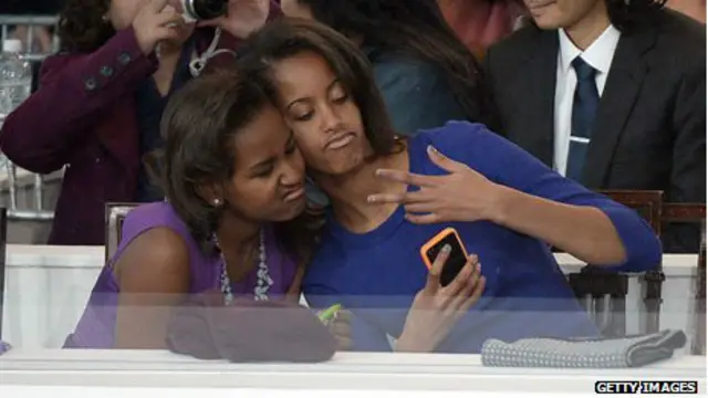 Доньки Обами фотографуються на смартфон