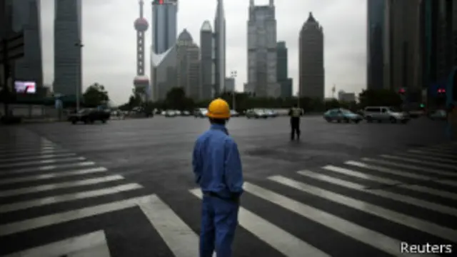 operário chinês olha para arranha-céus | Foto: Reuters