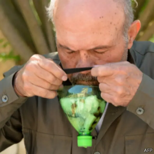 Сириец, примеряющий самодельный противогаз