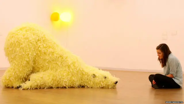 पूर्वी लंदन की व्हाइटचैपल गैलरी में रखे गए पत्थर के बने बड़े ध्रवीय भालू को पीले फर से ढका गया है.