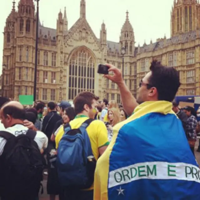 Manifestante tira foto com seu telefone celular em frente à Abadia de Westminster (Bruno Garcez / BBC Brasil)