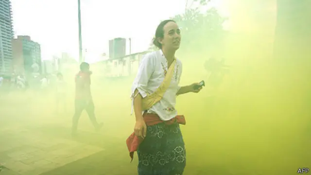 Manifestante foge de gás em São Paulo | Foto: AFP