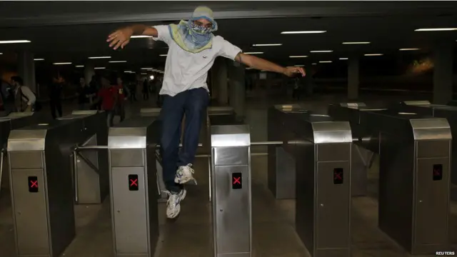 محتج يقفز فوق حاجز التذاكر كرمز لرفضه زيادة اسعار المواصلات. 