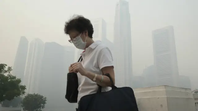 Seorang wanita memakai masker di Singapura