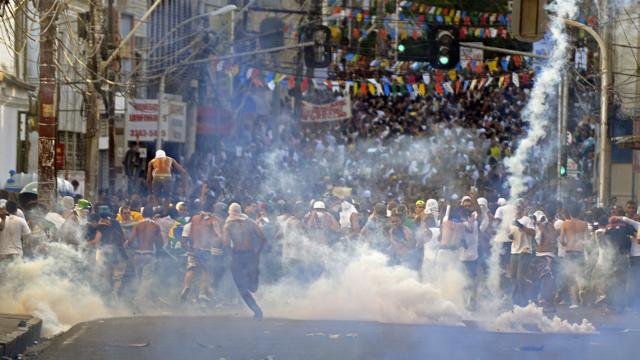 Manifestantes correm da fumaça de bombas de gás lacrimogêneo em Salvador