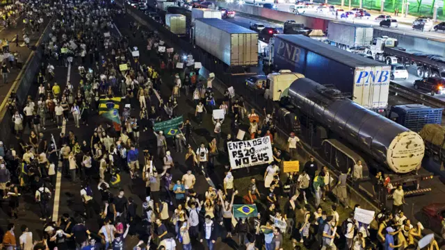 ساو جوسيه دوس كامبوس - متظاهرون يحتلون جانبا من شارع رودوفيا دوترا. كانت شرارة الاحتجاجات بدأت الأسبوع الماضي بعد قرار الحكومة زيادة تعريفة تذاكر الحافلات من 3 ريالات إلى 3.20 ريالات. (رويترز)